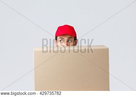 Packages And Parcels Delivery, Covid-19 Quarantine And Transfer Orders. Scared Courier In Red Unifor