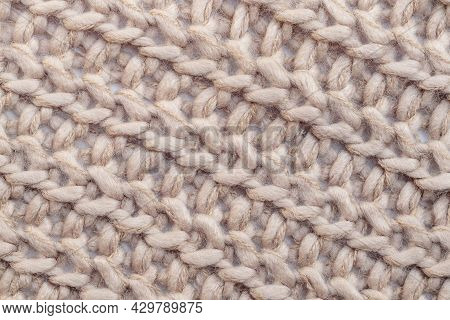 Close Up Of Beige Textile Texture. Woolen Knitted Fabric Background. Detailed Warm Woolen Scraf.