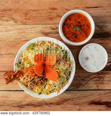 Traditional Hyderabadi Chicken Dhum Biryani Made Of Basmati Rice Cooked With Masala Spices, Served W