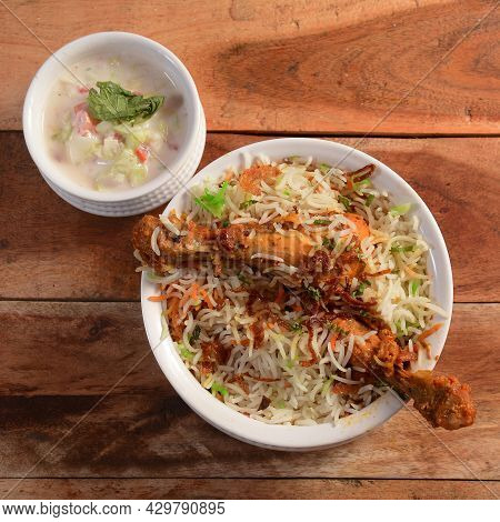 Traditional Hyderabadi Chicken Dhum Biryani Made Of Basmati Rice Cooked With Masala Spices, Served W