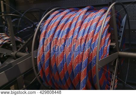 A Roll Of Colored Rope On A Metal Holder. Twine Coil For Lifting Heavy Objects, Rope In A Reel.