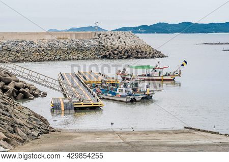 Taean, South Korea; July 30,2021: Fishing Trawlers Moored To Floating Dock In Seaport On Overcast Mo