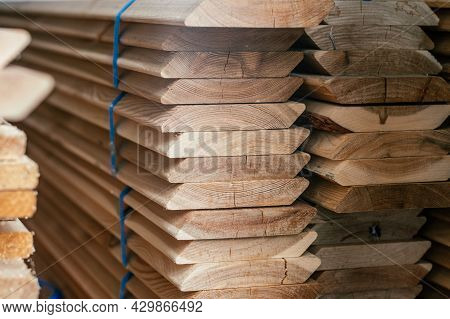 View Of Ends Of Stacked Edged Larch Boards With Beveled Edge, Planken For Construction Of Fence Or C