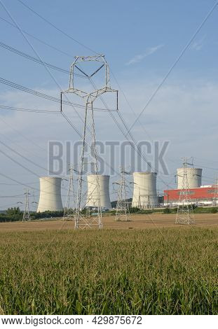 Nuclear Power Plant With Field Of Maize Or Corn In Front Of It. Nuclear Power Station. Cooling Tower