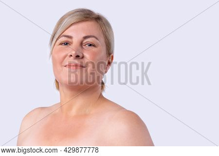 Blonde Hair Cut Woman With Pleasant Appearance Smiling Posing At A Camera With Bare Shoulders.