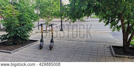 Dockless Electric Scooters On The Sidewalk. Electric Scooter - Affordable Urban Transportation. Cons