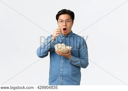 Leisure, Lifestyle And People Concept. Thrilled And Amazed Asian Guy Watching Awesome Movie Or Tv Se
