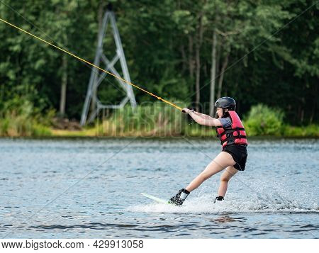 Straz, Czechia. 29th Of July, 2021. Wake Boarding  Boy On Lake, The Forest In Blurry Background.