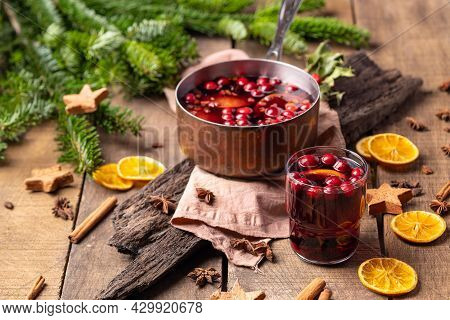 Hot Mulled Red Wine Drink With Citrus, Apples, Cinnamon Sticks, Cloves And Anise In Cooking Pan On W