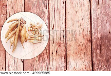 Kaempfer (boesenbergia Rotunda) On A Round, Light Green Cutting Board. The Left Side Of The Picture 