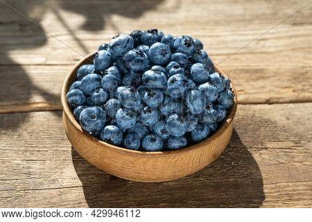 Blueberries In A Round Wooden Plate Close-up. Blueberries On A Wooden Background. Healthy Food. Harv