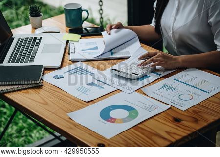 Close Up Woman Calculating Using Machine Managing Household Finances At Home, Focused Biracial Male 