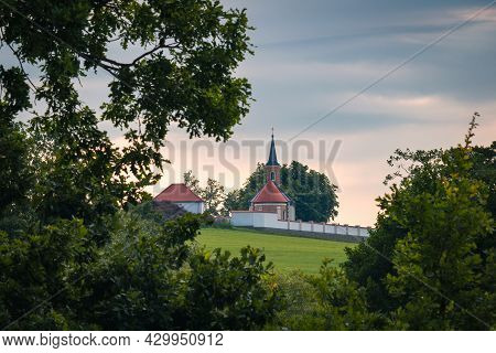 Small Chapel, Church In Village Kremze Cemetery With Trees At Cloudy Sky. Czech Republic Landscape