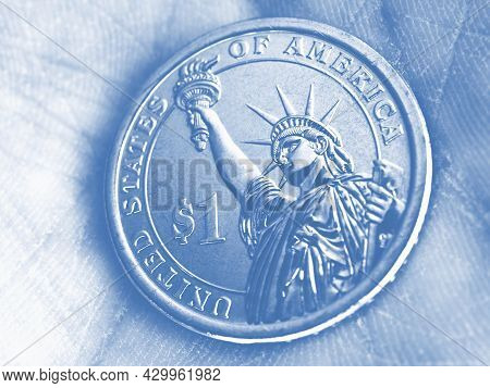 Us Coin Lies On The Palm. 1 One Dollar Coin Close Up. Light Pale Blue Tinted Background Or Wallpaper