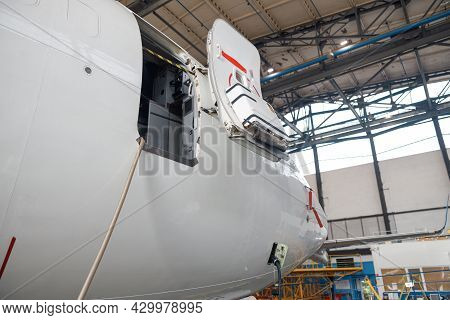 Open Aircraft Door And Cocpit. Passenger Airplane On Maintenance Repair In Airport Hangar