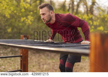 Athletic Man Doing Pullups While Doing Morning Training Session In A Street Workout Park