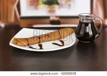 หวาน pancakes บนแผ่นกับนมข้นบนโต๊ะในห้อง