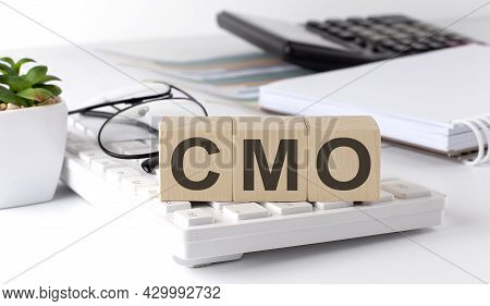 Cmo Chief Marketing Officer Written On Wooden Cube On Keyboard With Office Tools