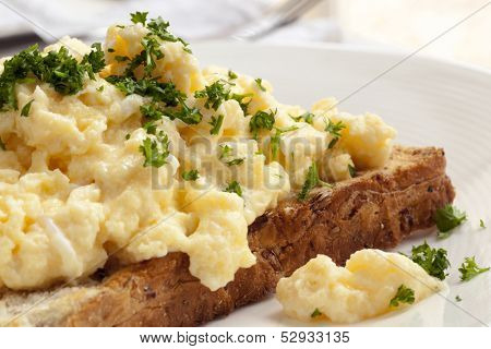 Scrambled eggs on toasted wholegrain bread.  Garnished with parsley.