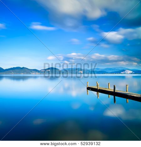 Wooden Pier Or Jetty And On A Blue Lake Sunset And Sky Reflection On Water. Versilia Tuscany, Italy