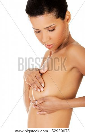 Young woman doing self brast examination, holdin her breasts.Isolated on white.