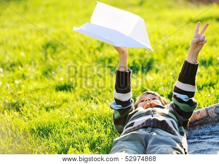 Happy kid enjoying sunny late summer and autumn day in nature on green grass