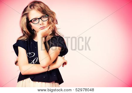 Pretty ten years girl looking sad. Pink background.