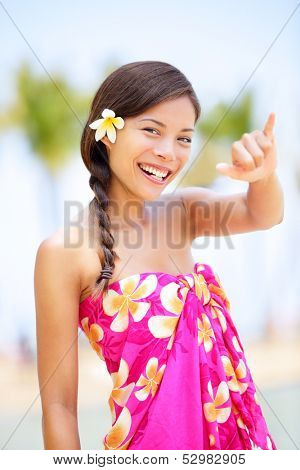 Hawaii beach woman making Hawaiian shaka hand sign. Pretty and free asian girl enjoying vacation holiday on beach resort with palm trees. Mixed race female on Big Island, Hawaii