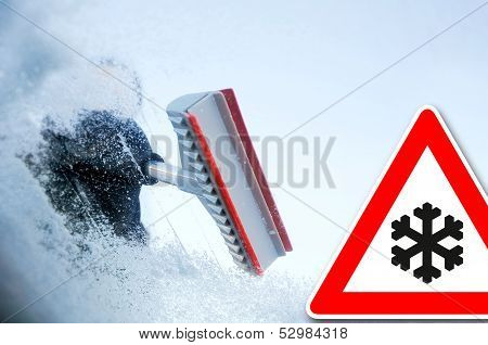 winter driving - scraping ice from a windshield