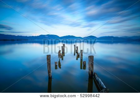 Wooden Pier Or Jetty Remains On A Blue Lake Sunset And Sky Reflection On Water. Versilia Tuscany, It
