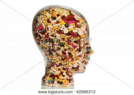 a head made of glass filled with many tablets. photo icon for drugs, abuse and addiction tablets.