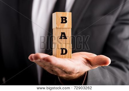 Businessman Holding Alphabet Blocks Reading - Bad