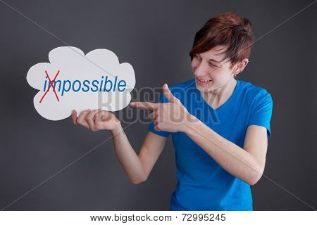 Young boy holding board (im)possible word