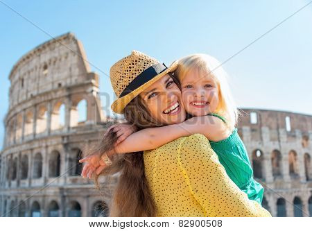 Portrait Of Mother And Baby Girl Hugging In Front Of Colosseum In Rome, Italy