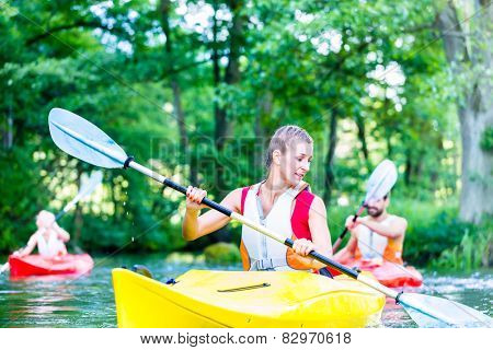 Friends paddling with canoe on forest river
