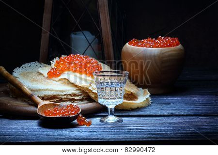 Pancakes With Red Caviar And A Wine-glass Of Vodka And An Old Lantern