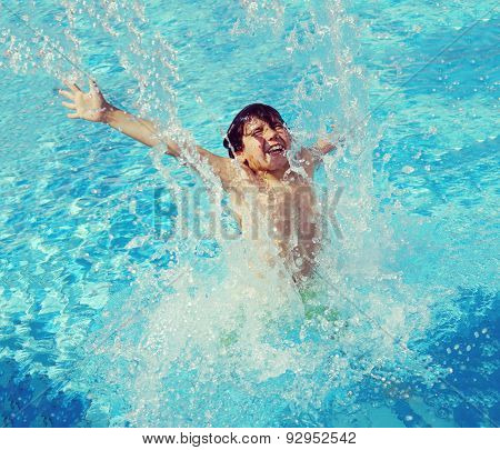 Child splashing in summer water pool