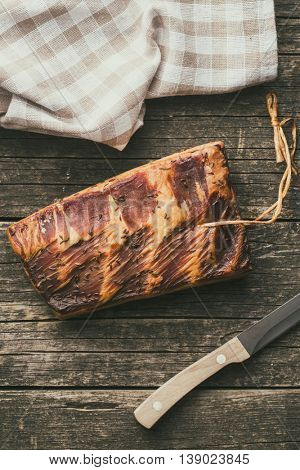 Fresh smooked bacon on old wooden table.