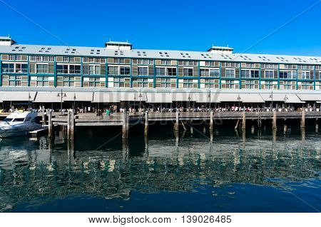 Finger wharf restaurants and hotel in Woolloomooloo bay with unrecognisable people in the distance. Sydney Australia