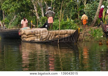 Allepey, Kerala, India - March 31, 2015: Some men transport, overload, put on them head bag of rice
