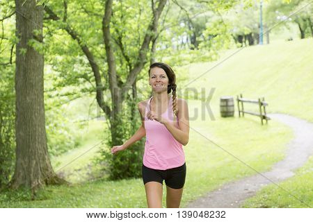 A sporty woman running outdoors in park
