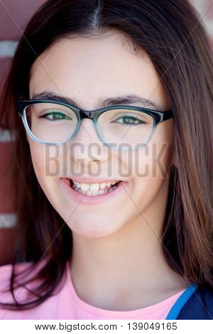 Preteenager girl next to a red brick wall with nice expression