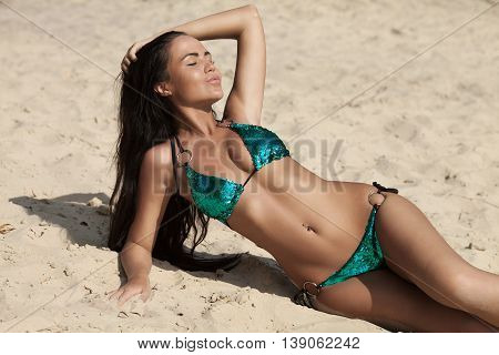 attractive sexy asian woman in bikini, outdoor shot in sand, summer day. Beauty at the beach sand around. Fashion shot of beautiful woman on the beach.