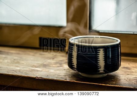 Hot Japan Tea Cup On Wood Bar Beside Window