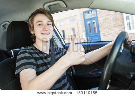 A Teenage boy and new driver behind wheel of his car