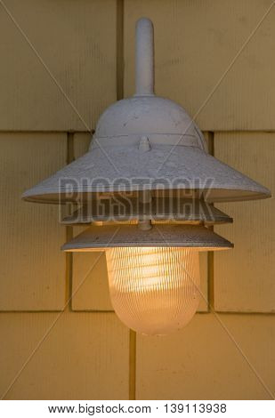 Street Light Fixture Mounted On A Wall Glowing Soft Yellow Light