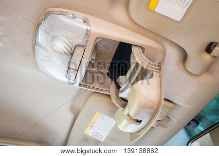 Open sunglasses box/case or storage box and light button switch in car interior detail