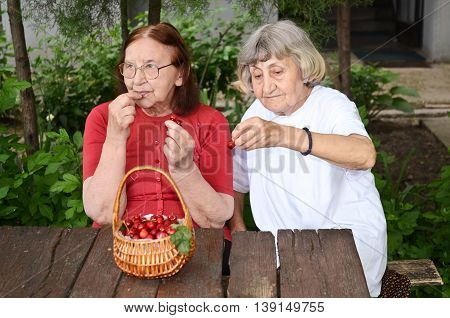 Senior citizens enjoying their day eating cherries