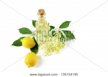 Sambucus nigra elderberry sirup on white background. Bottle of excellent syrup with flowers leaves and lemon.