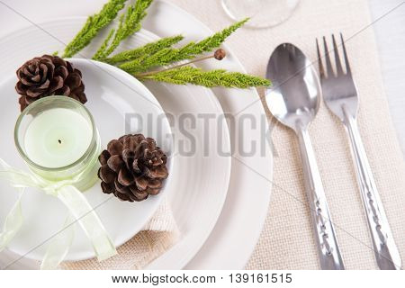 Dining table setting white plate with candles flower vintage crockery and spoon fork